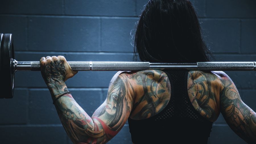Coach spotting a member through a heavy bench press set