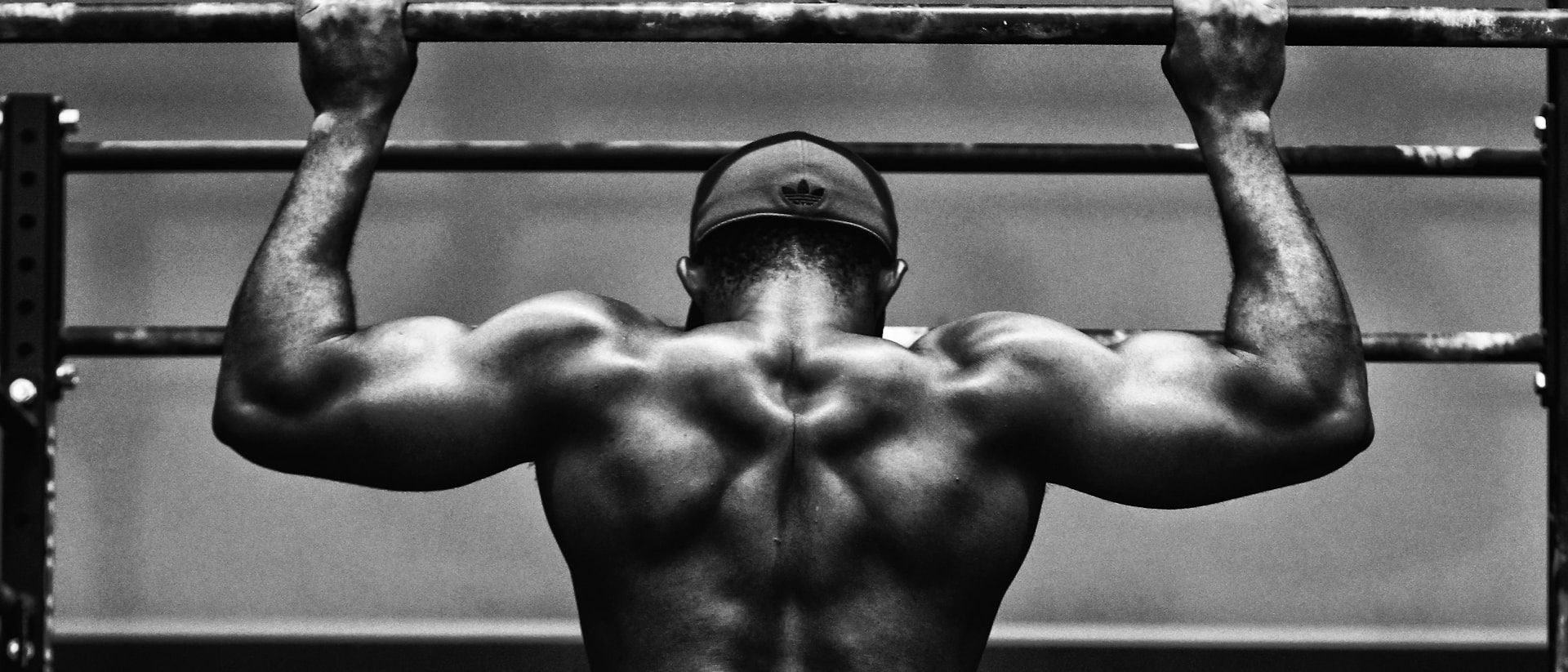Black-and-white photograph of a member performing pull-ups
