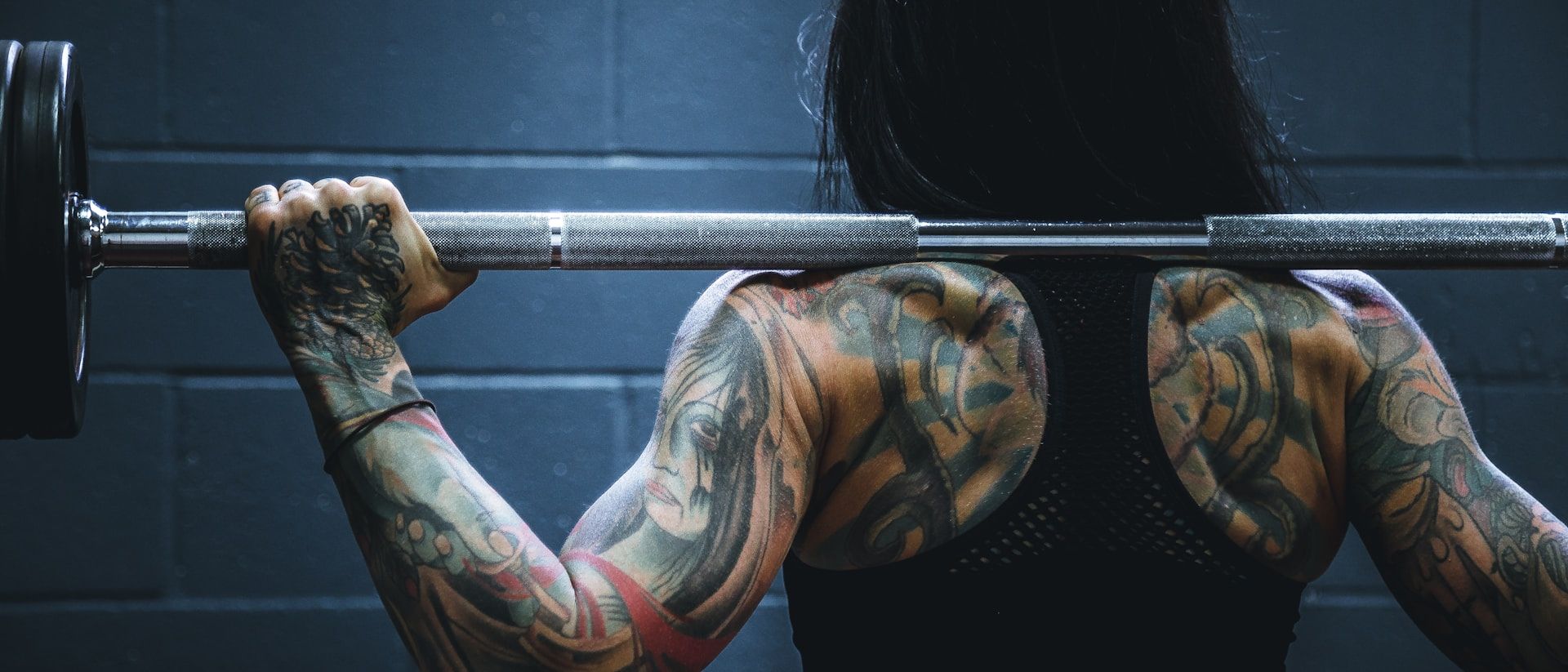 Member pressing a loaded barbell on a flat bench