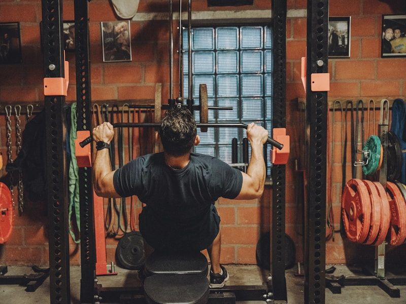 Personal Training at FITZONE — Member working through a guided set at a squat rack