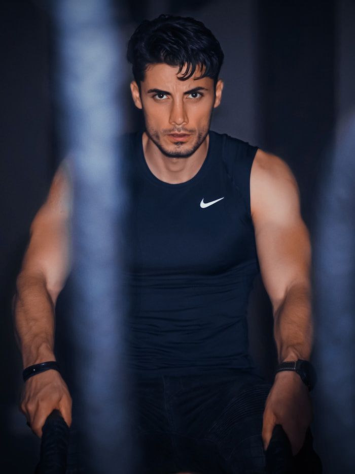 Portrait of head trainer Alex Carter beside battle ropes